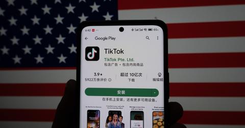 The TikTok app on a smartphone with an American flag in the background