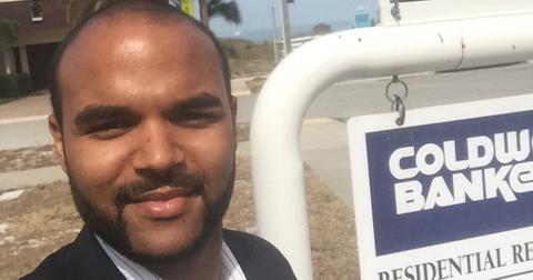 Justin Simpson standing next to a Coldwell Banker sign