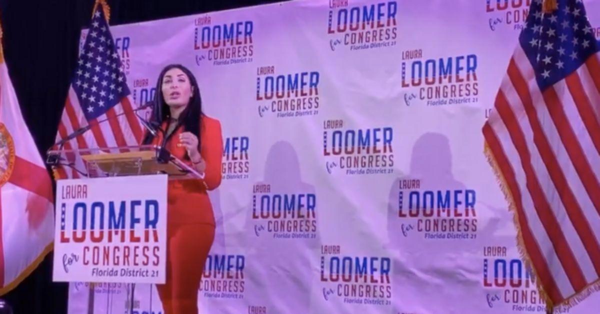 Laura Loomer speaking at a podium while campaigning for Congress.