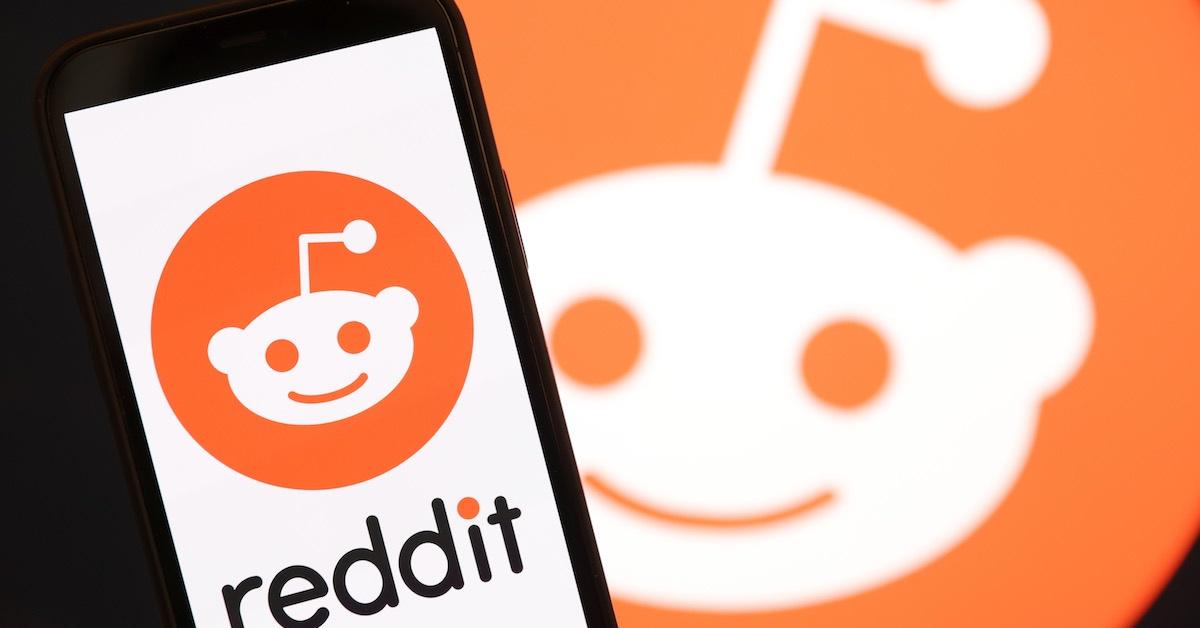 A Reddit logo on a phone and in the background