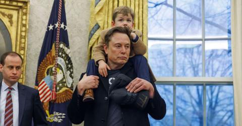 Elon Musk with X on his shoulders in the Oval Office.