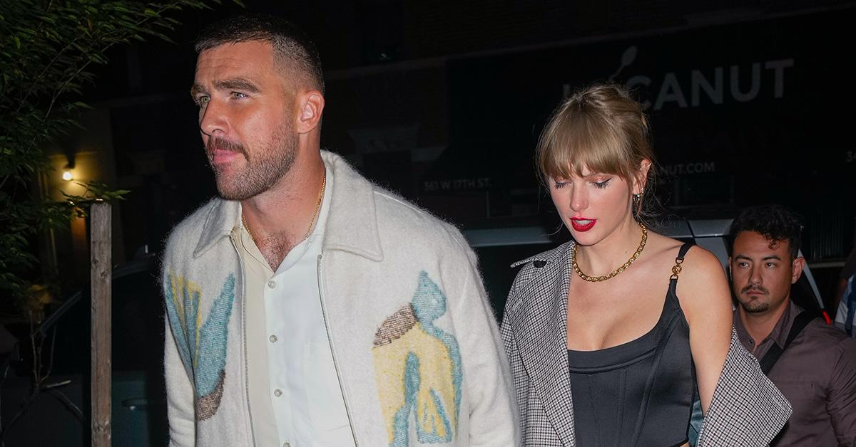 Travis Kelce and Taylor Swift holding hands while walking. 