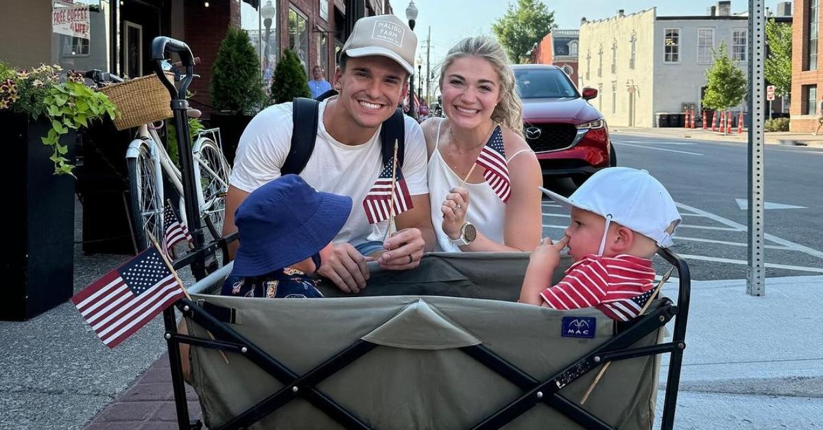 Matt and Abby Howard kneel behind their kids in a wagon