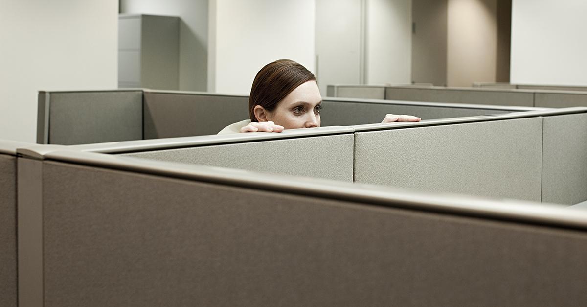 A woman hides pictures of herself around her office after getting laid off