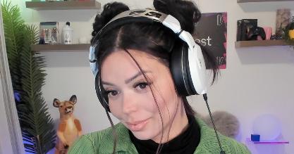 Adept wearing white headphones with space buns