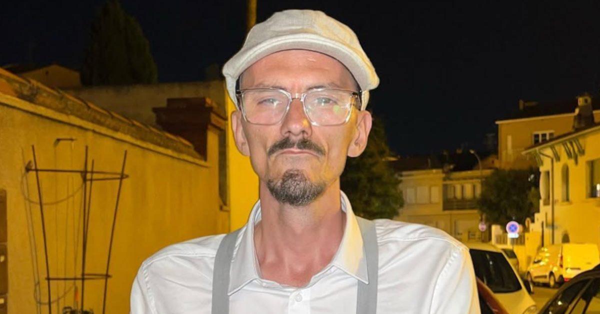 Jean Pormanove standing outside in a neighborhood at night.