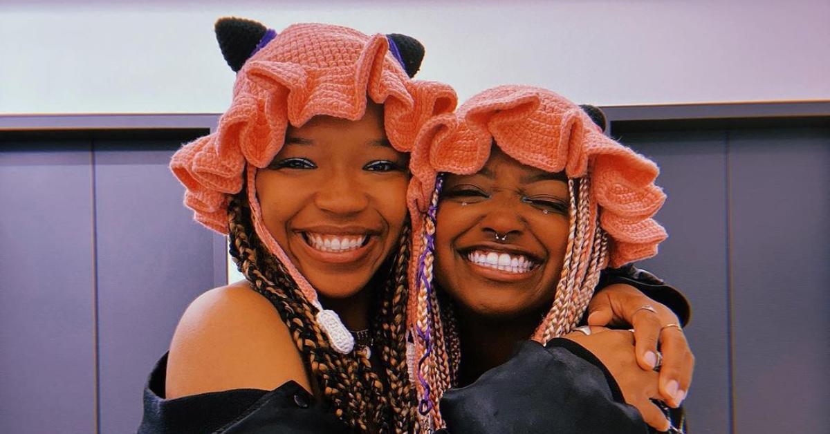 Bobbi Lanea and Folayan Kunerde wear matching crochet hats and smile really big while they hug.