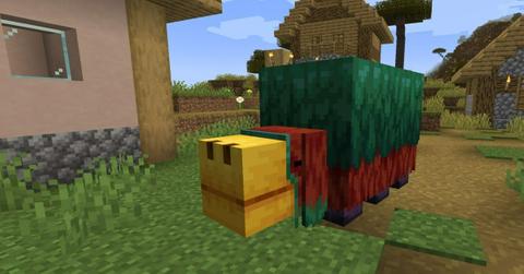 The Sniffer mob in Minecraft next to a building.