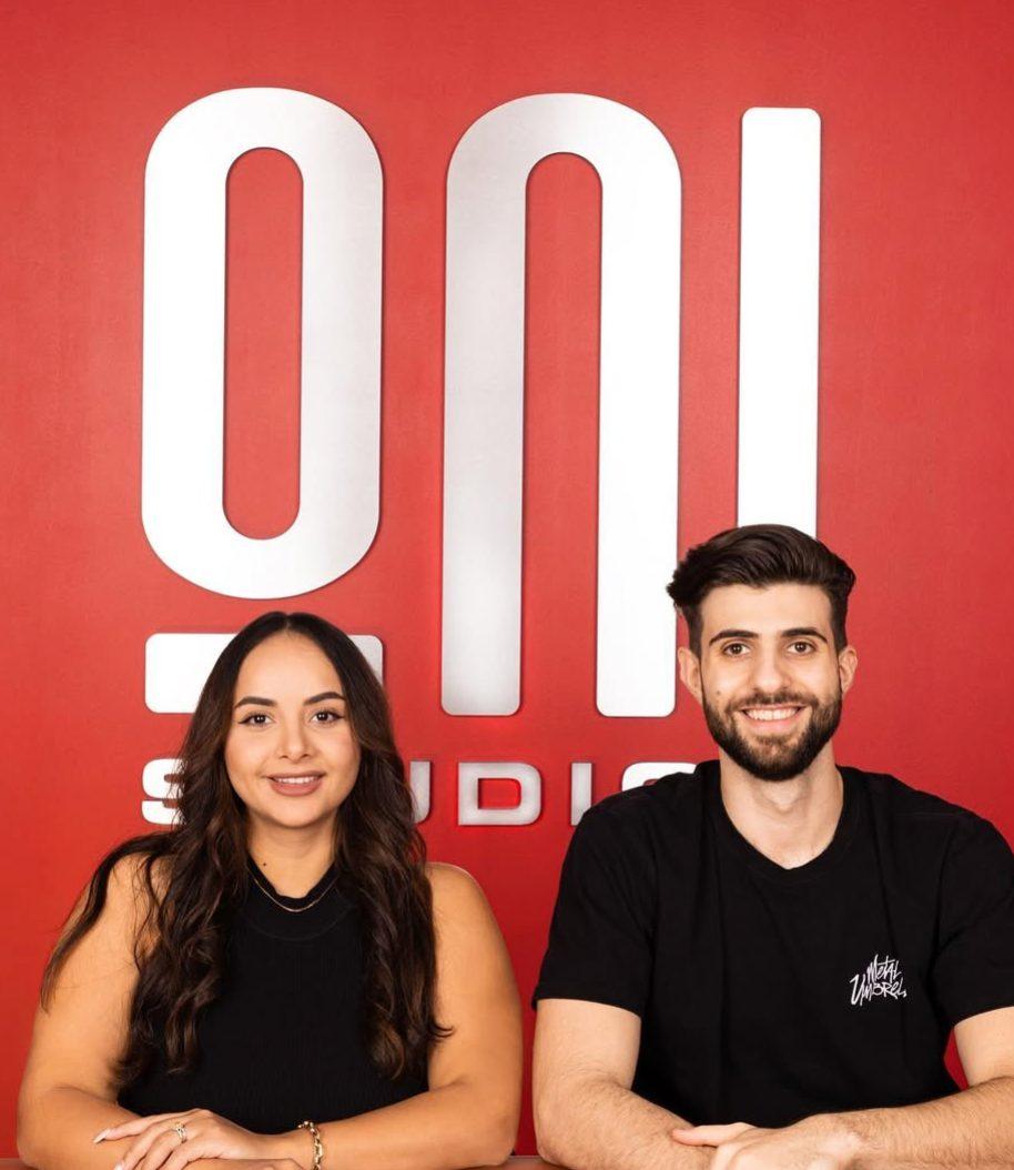 SypherPK with his then-wife Daniela with their company brand logo behind them.