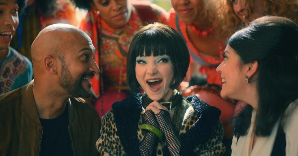 Keegan Michael-Key as Josh, Dove Cameron as Jenny, and Cecily Strong as Melissa smiling in 'Schmigadoon'.