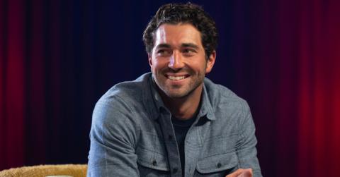 'The Bachelor' Season 28 lead Joey Graziadei sits and sports a grin while dressed in a cozy gray flannel utility shirt