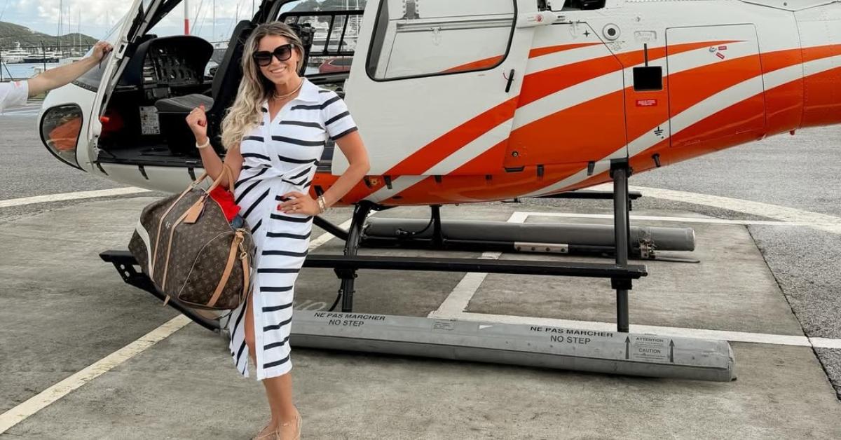 Amanda Frances stands in front of a helicopter.