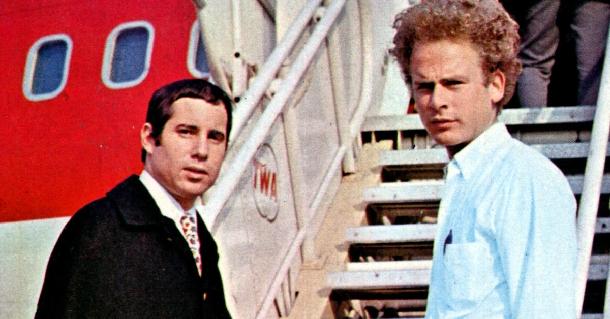 Paul Simon and Art Garfunkel on the steps leading up to an airplane