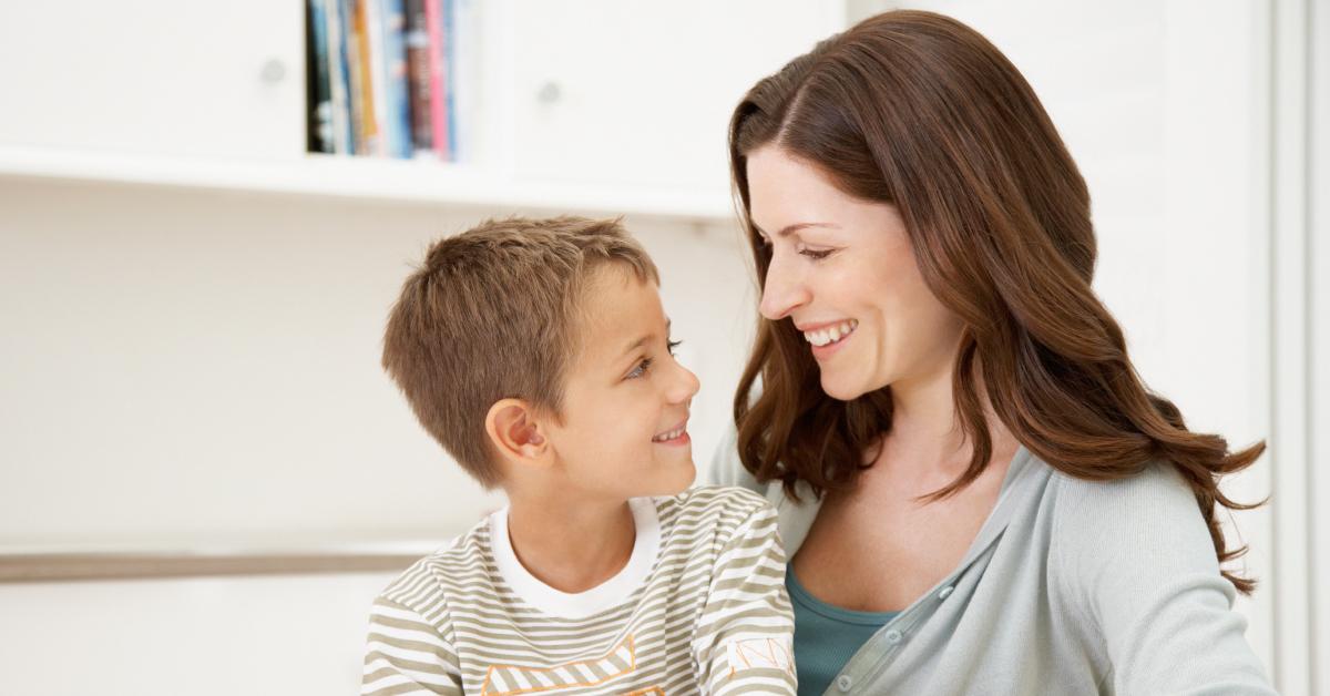 A mother and son smiling at each other.