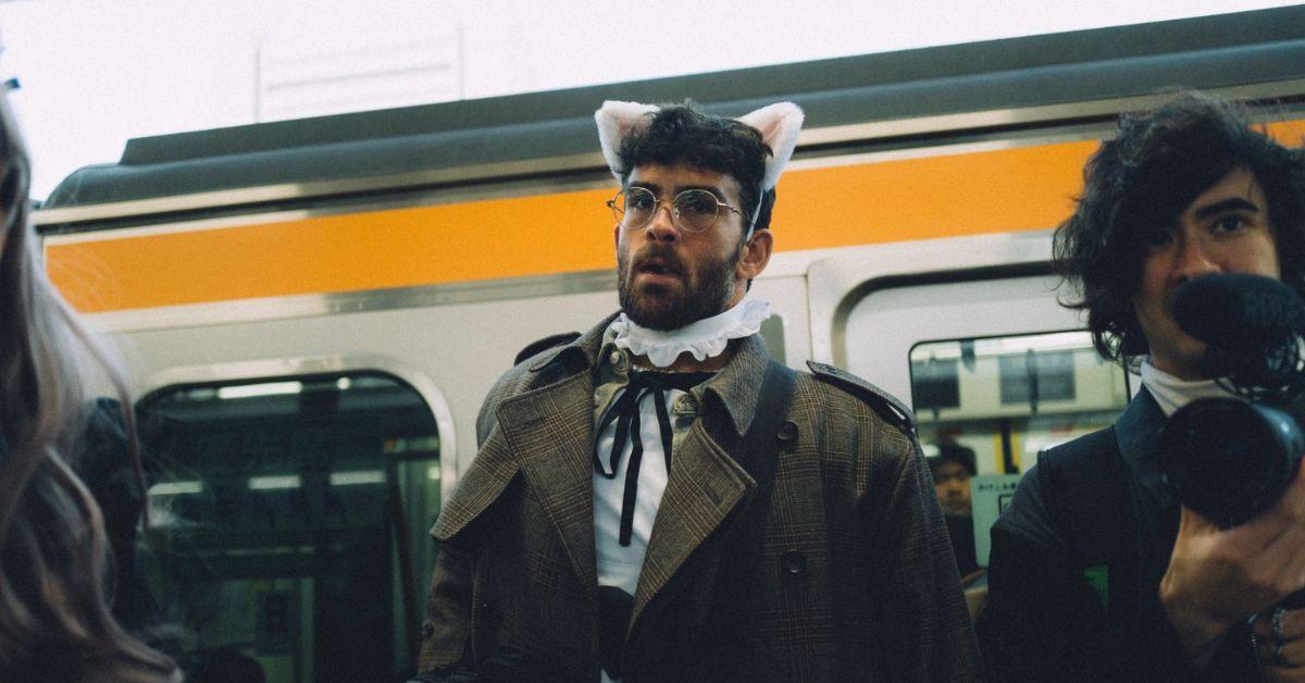 Hasan Piker wearing bunny ears in front of a train in Japan. 