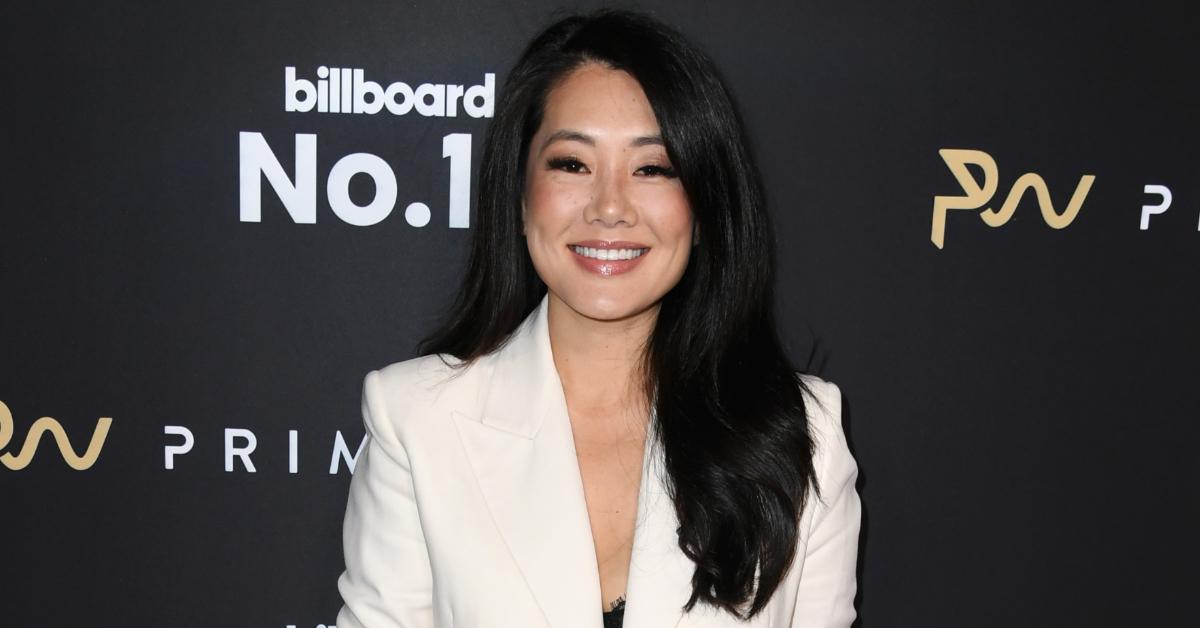 Crystal Kung Minkoff posing on the red carpet at the 2024 Primary Wave Annual Grammy Pre-Party in a white suit.