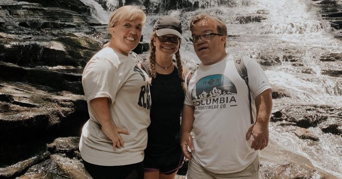 Anna Johnston in front of a waterfall with her parents