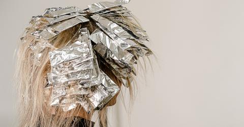 Foil on models hair. Bleaching or dyeing process - Stock Image