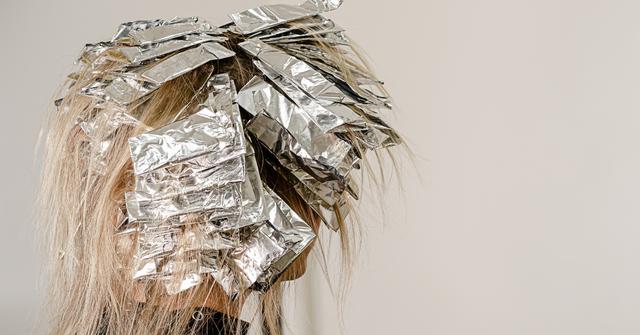 Foil on models hair. Bleaching or dyeing process - Stock Image