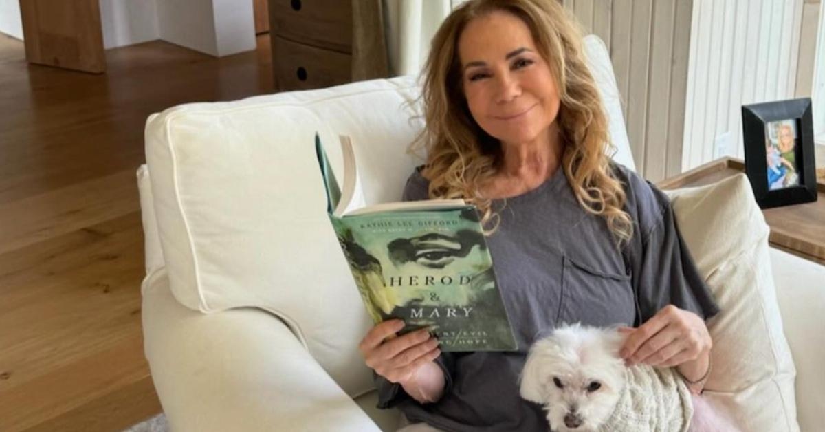 Kathie Lee Gifford sitting on white couch with her dog and her book "Herod & Mary"