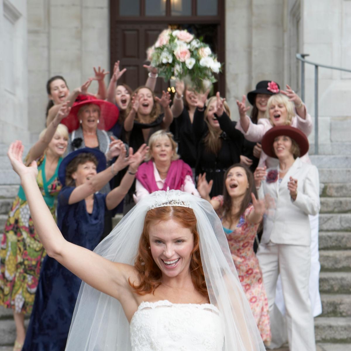 Bride tosses bouquet to the women behind her after wedding