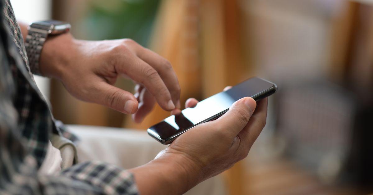 man holding iPhone at work