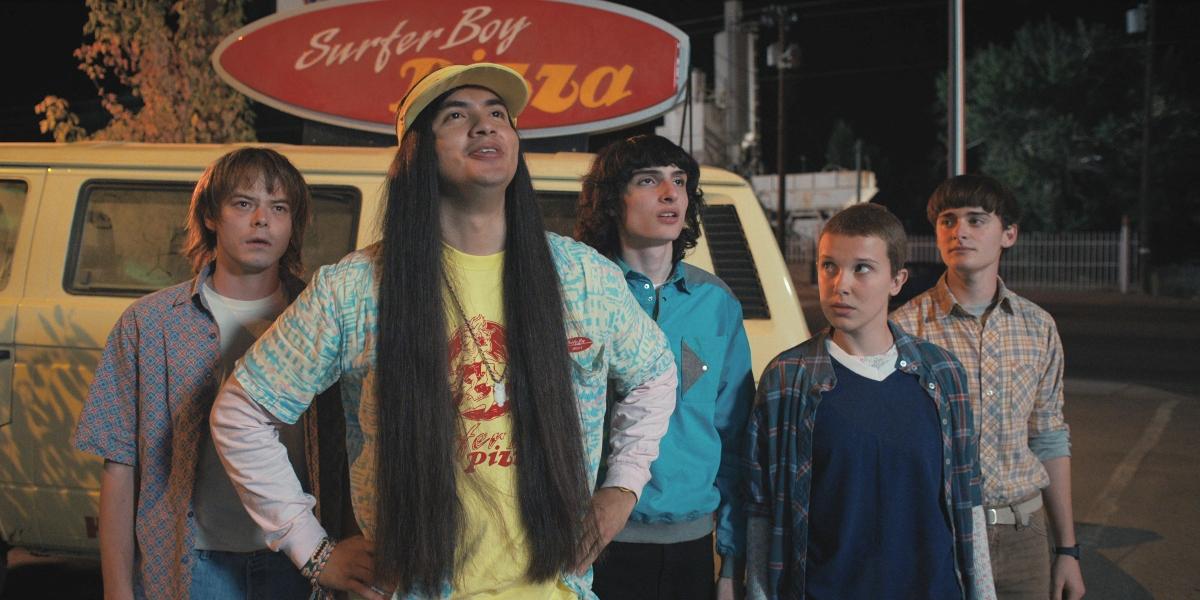 Jonathan, Argyle, Mike, Eleven, and Will stand outside of the pizza van on Stranger Things.