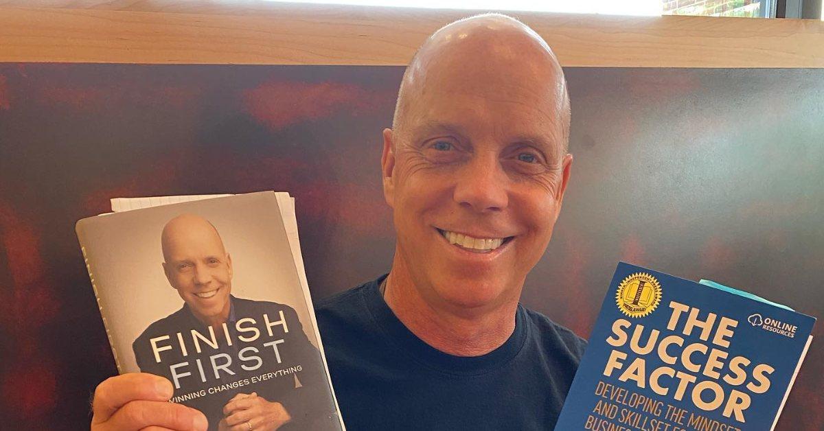 Scott Hamilton holds up his books