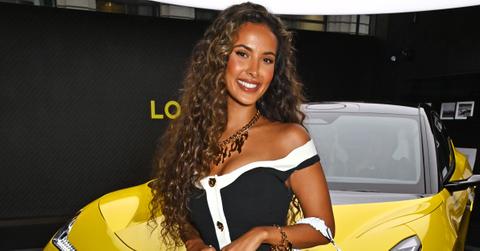 maya jama poses in front of yellow car
