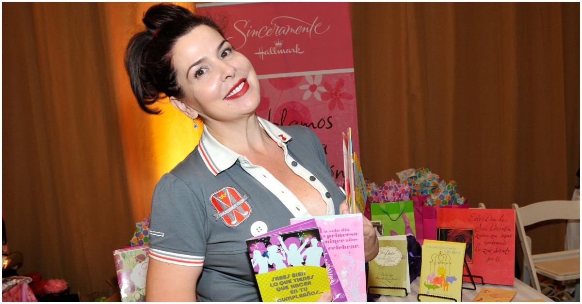 Jackie Guerra smiling at an event while holding cards.