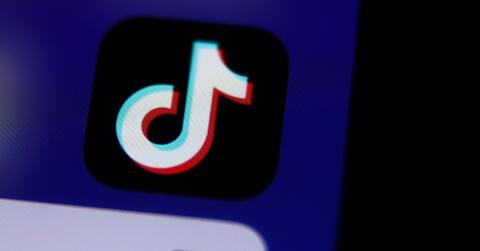 TikTok logo on a phone screen with a blue background.