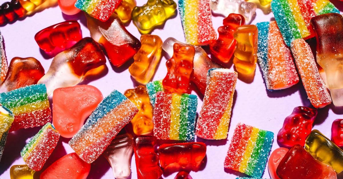 Collection of different gummy candy on white table