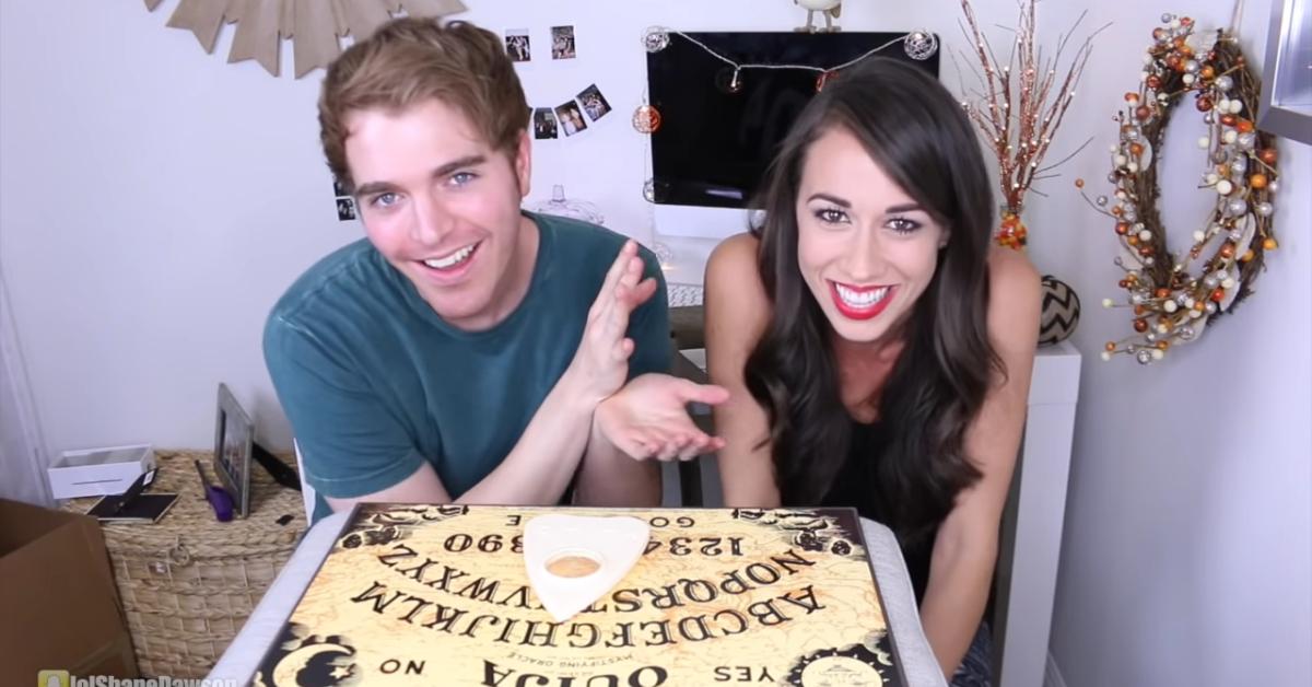 Shane Dawson and Colleen Ballinger play with a ouija board.