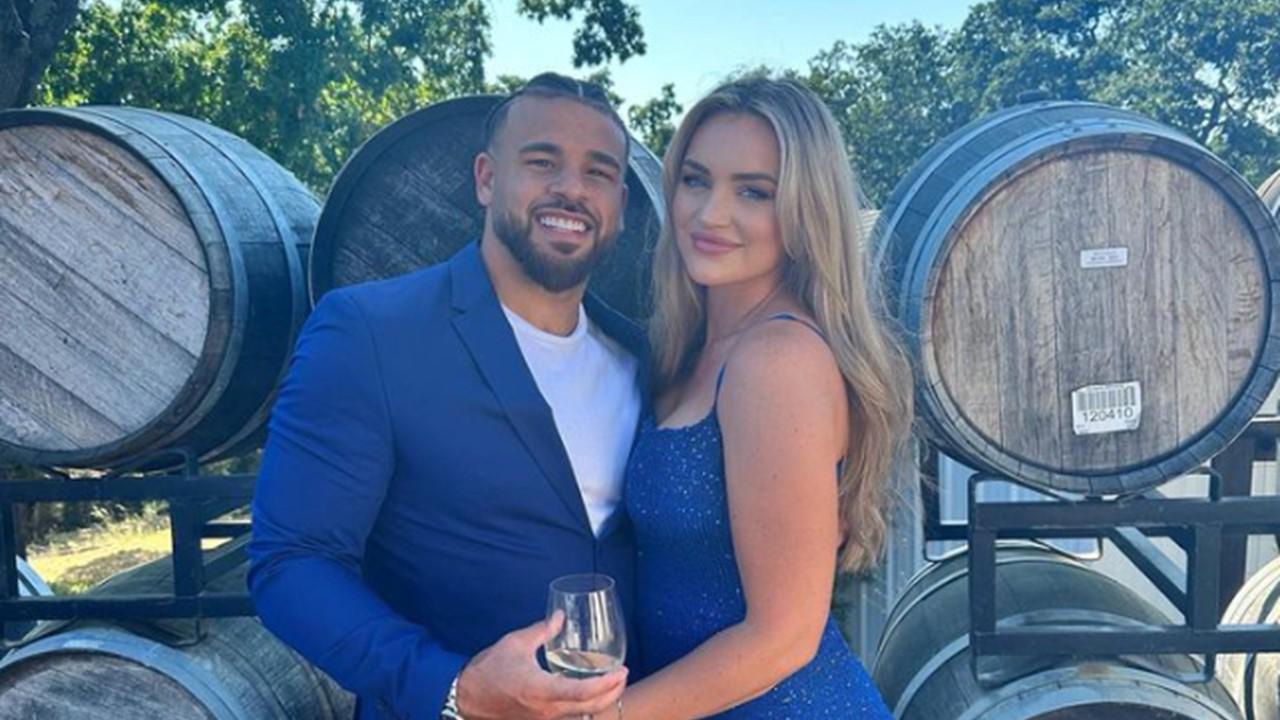 Cory Wharton and Taylor Selfridge standing in front of wine barrels 