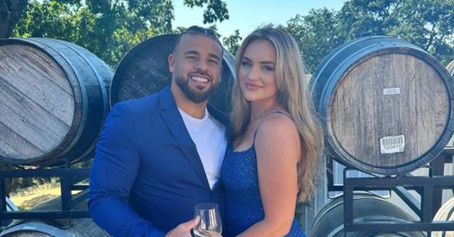 Cory Wharton and Taylor Selfridge standing in front of wine barrels
