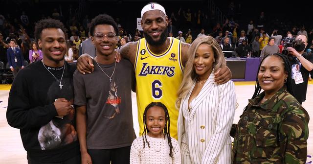 LeBron James poses for a picture with his wife, kids, and mom at the end of a game.
