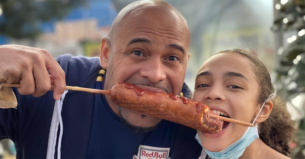 Hezly Rivera eating a corndog with her dad. 