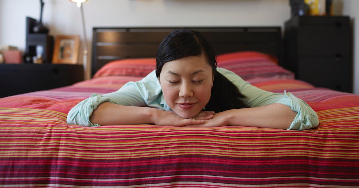 woman resting on bed with eyes closed