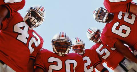 Football players in a team huddle/