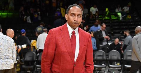 Stephen A. Smith wearing a red suit at a Los Angeles Lakers game.