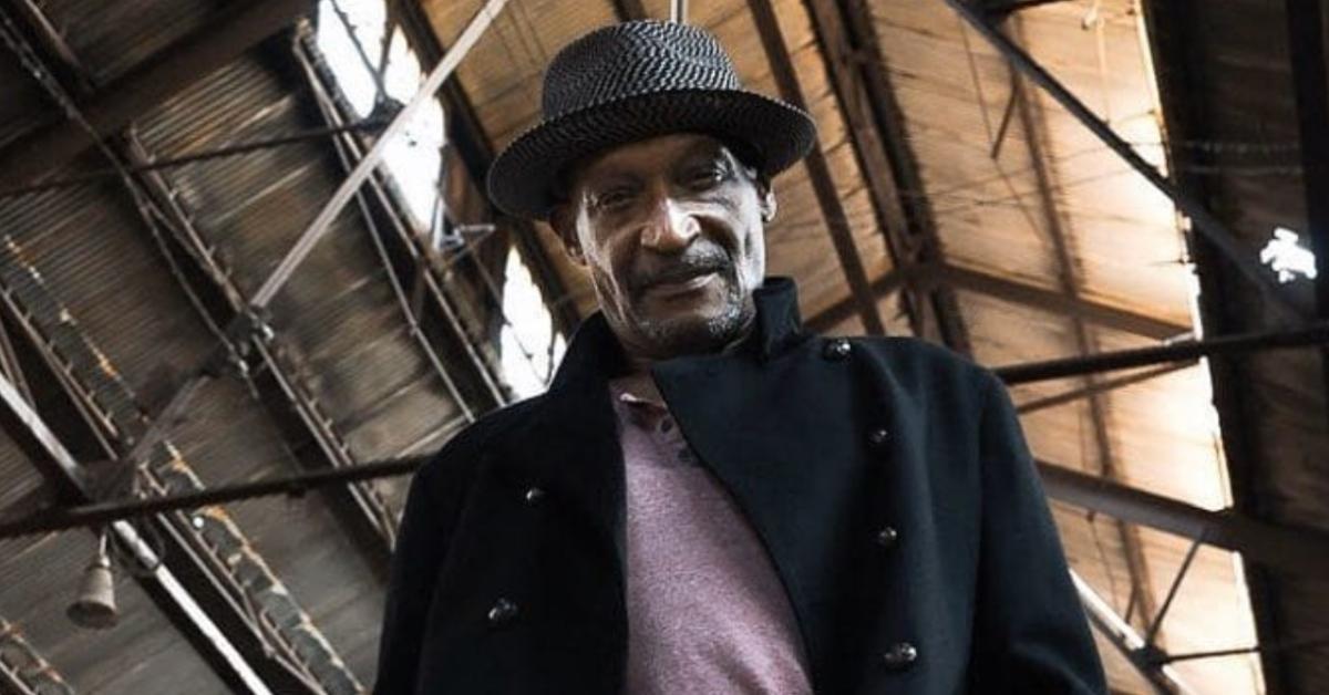 Tony Todd wearing a hat and a black coat.