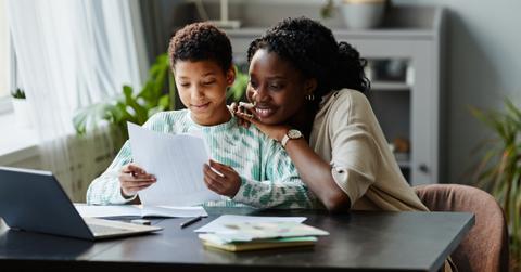 A mom helps their child with their homework.