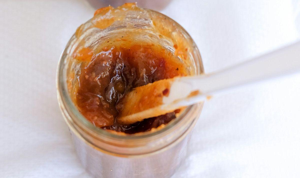 Mango chutney jam being mixed in a jar