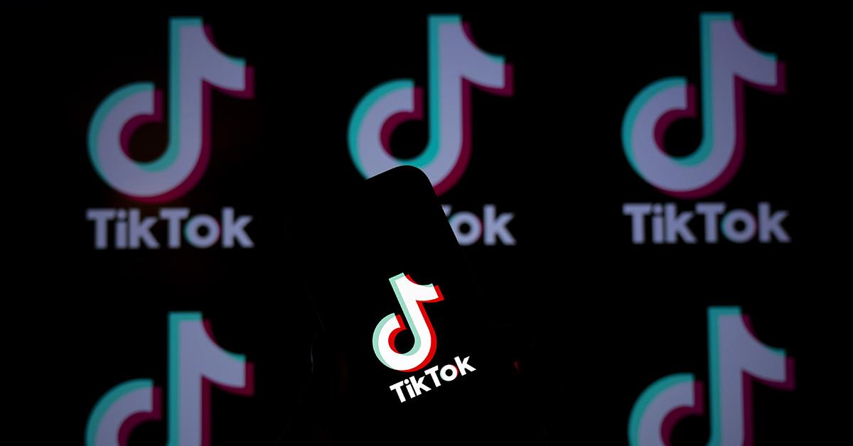 A TikTok logo on a phone with logos behind it. 