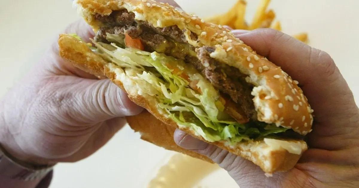 A person holding a half-eaten hamburger.