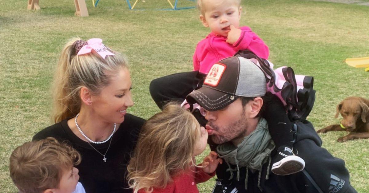 Anna Kournikova and Enrique Iglesias together with their three kids in the backyard.