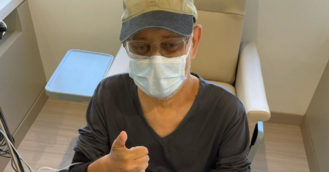 James Michael Tyler gives a thumbs up with a mask on after chemo