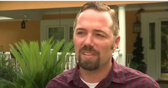 Sidney Moorer standing outside a house in a maroon shirt