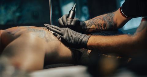 A tattoo artist working on a back.