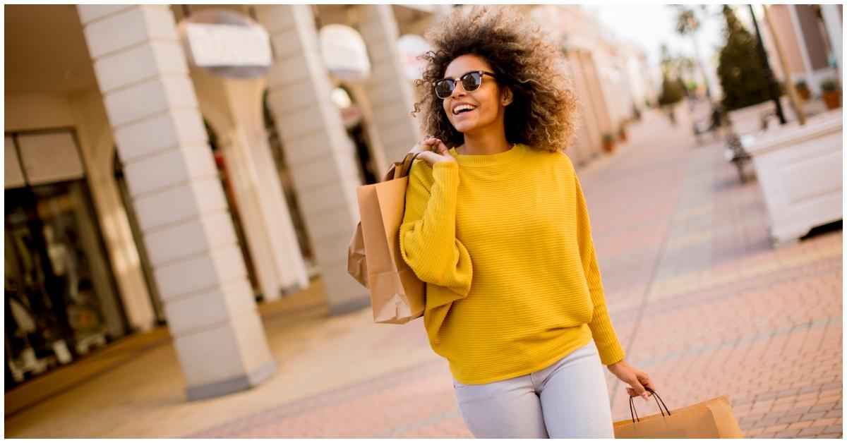 A Black woman shopping and holding shopping bags